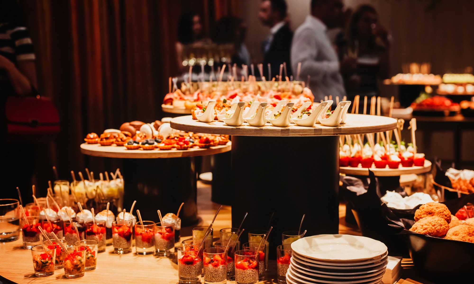 Full-service holiday catering appetizer display with passed bites and dessert cups at a Miami company party